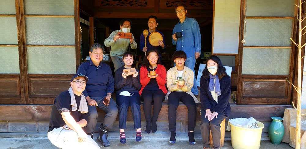 それぞれの木工作品を持って記念写真（左から加藤さん、高岡さん、研修生６人、青山さん）