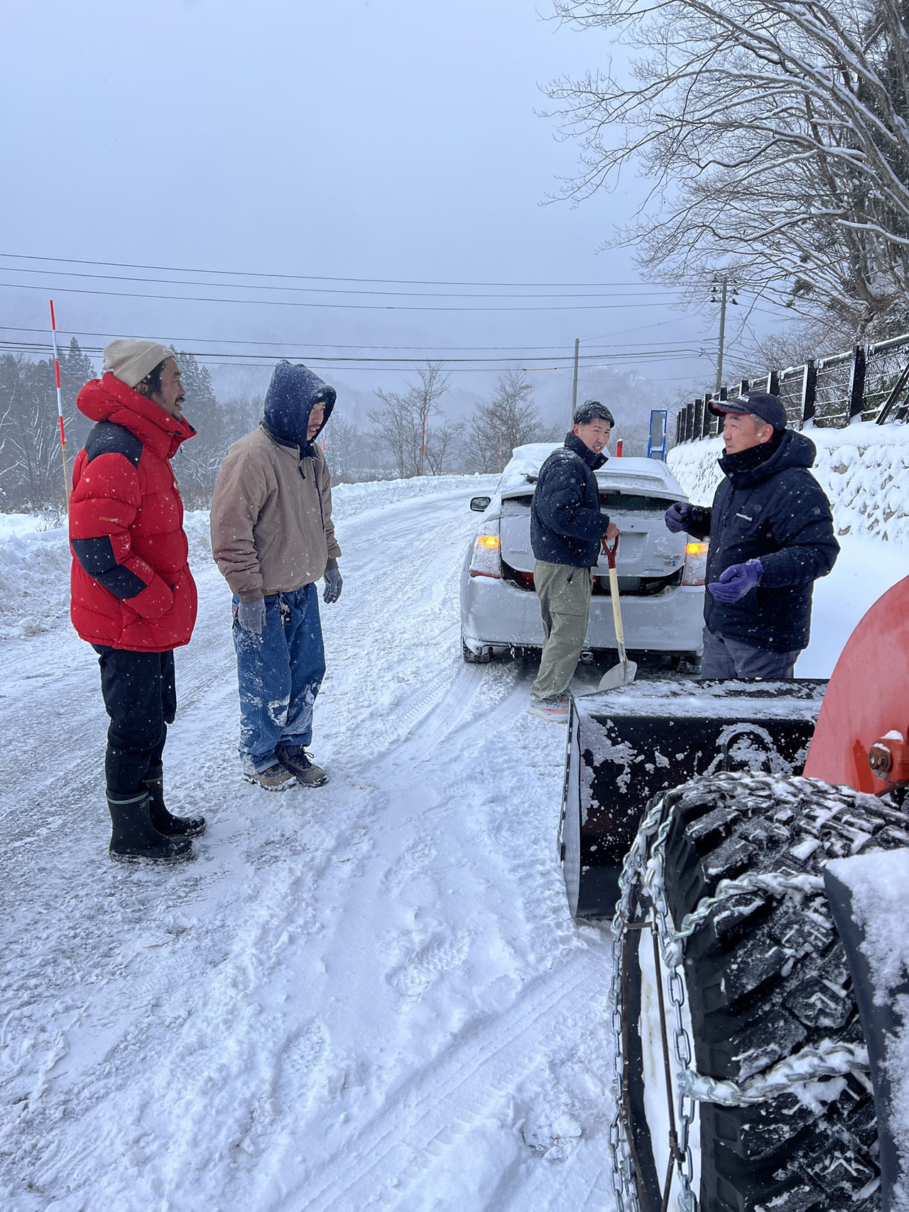 吹雪でホワイトアウトし車が脱輪。友人や通りがかりの地域の人々に助けられる（左端：溝口さん提供）
